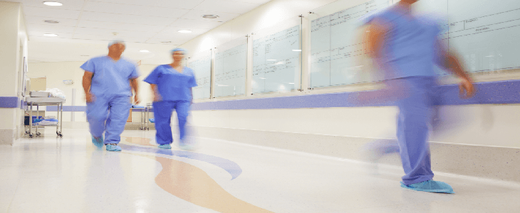 hospital workers walking through busy hallway
