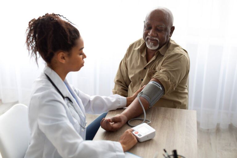 woman checking man's blood pressure