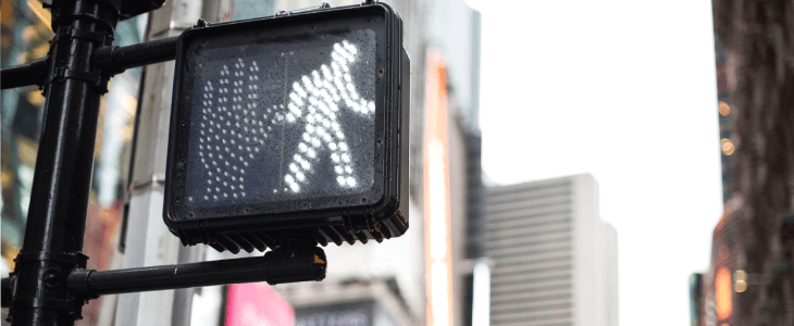 A crosswalk signal to let pedestrians know they are able to walk across the street.