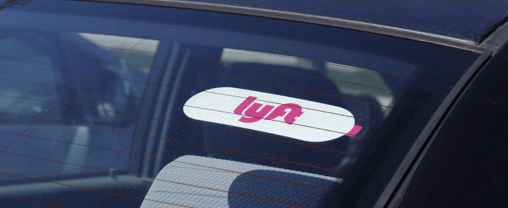 A car with a sticker on the windshield that reads "Lyft".