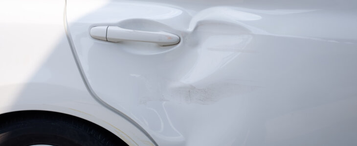 Body and rear door of white car get damaged by accident.