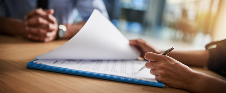 Cropped shot of a man and woman completing paperwork together at a desk