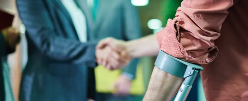Man wearing an arm brace, shaking hands with a lawyer.