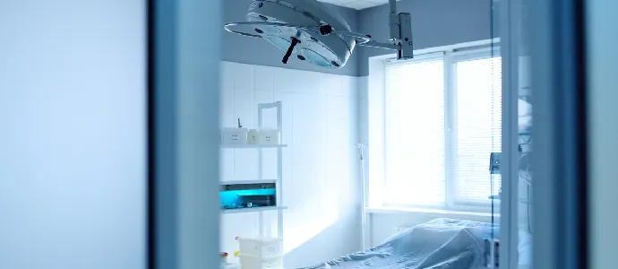 operating room and surgical lamp in a modern clinic through an open door
