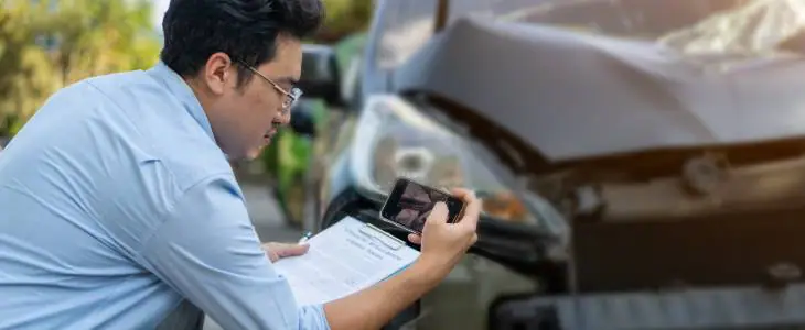 insurance agent looking at a car