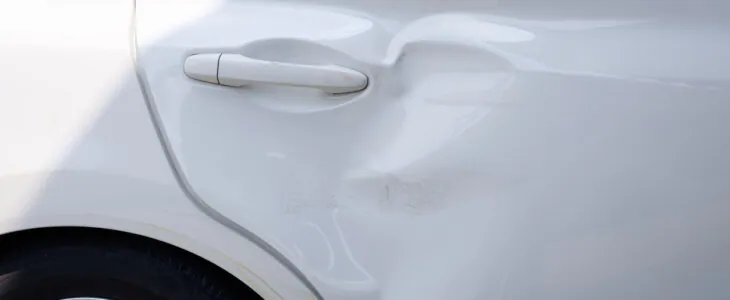 Body and rear door of white car get damaged by accident.